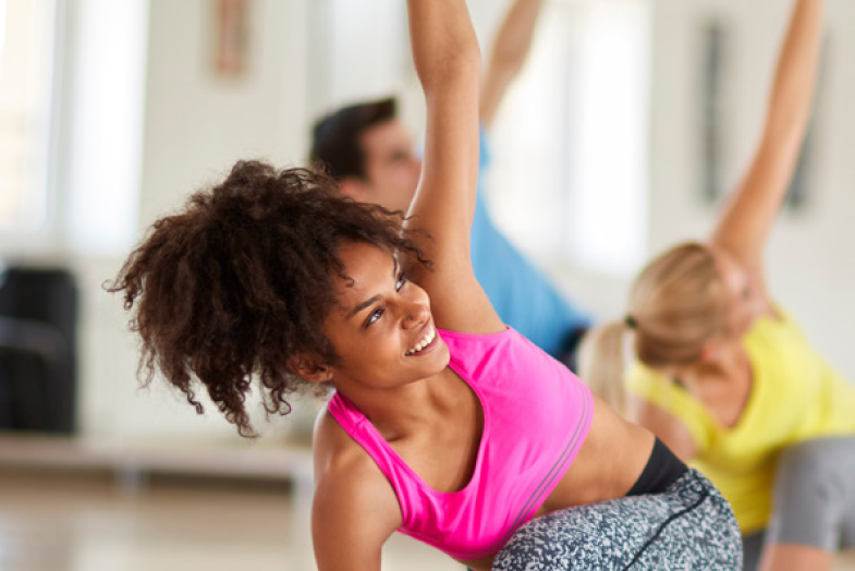 group of people with woman in front doing yoga 