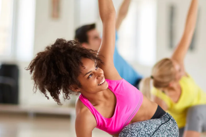 group of people with woman in front doing yoga