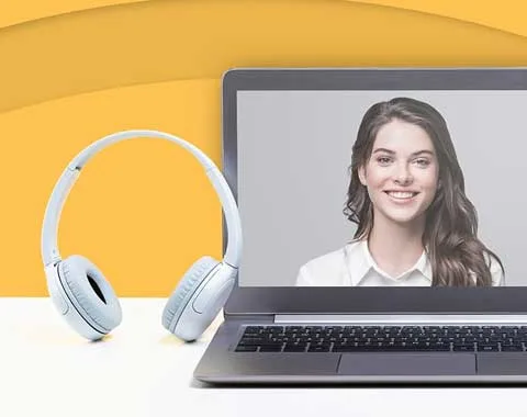 laptop screen and headset with woman smiling on screen.
