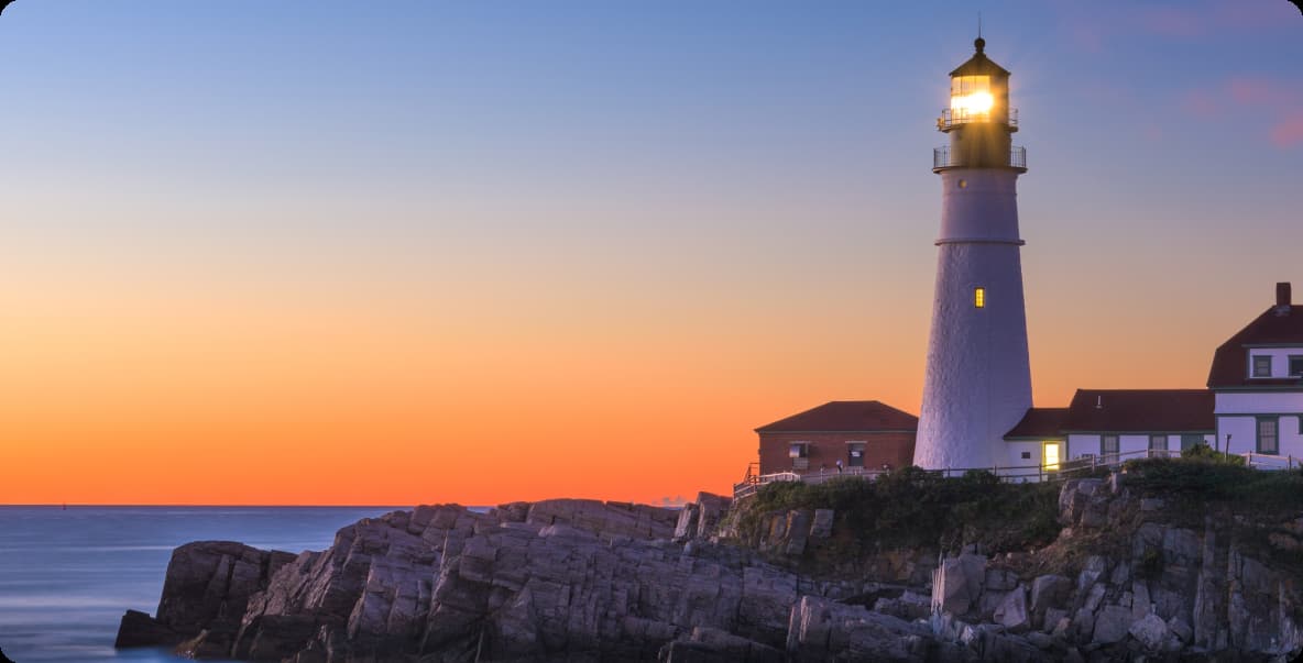 picturesque lighthouse at dusk on cliff at oceans edge. 