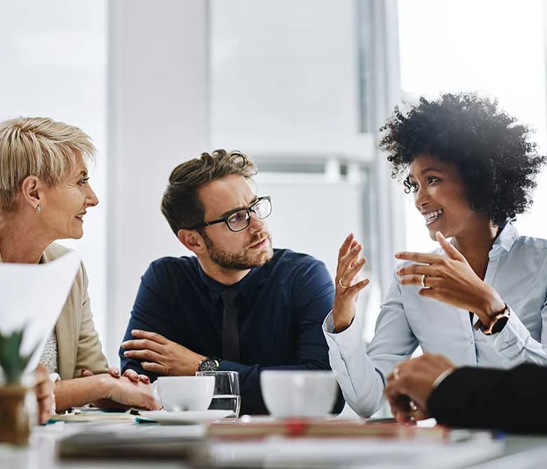 Office meeting with three coworkers in mid discussion