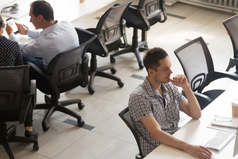 open office space with male colleagues sitting at desktop computers