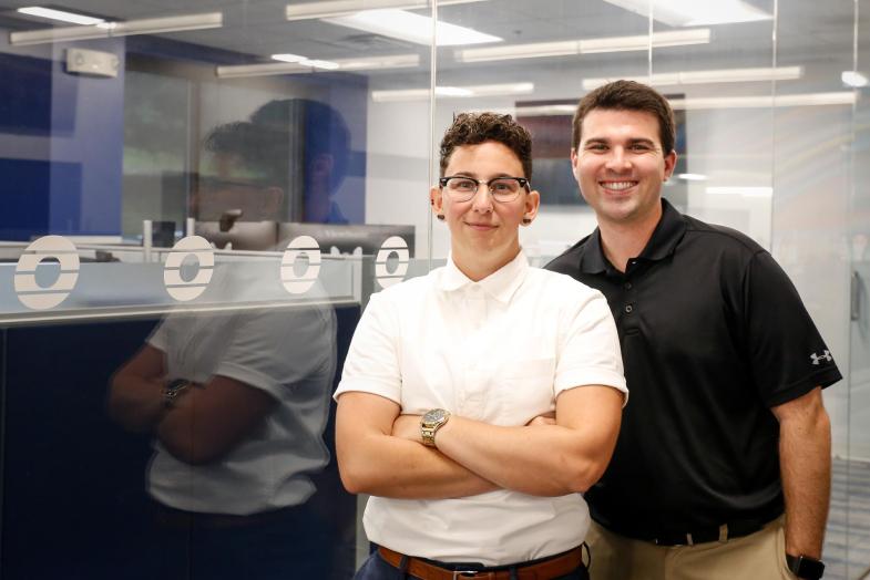 Two corporate Omnicable coworkers smiling at the camera