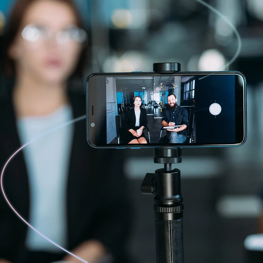 Image of two colleagues being filmed on smartphone video