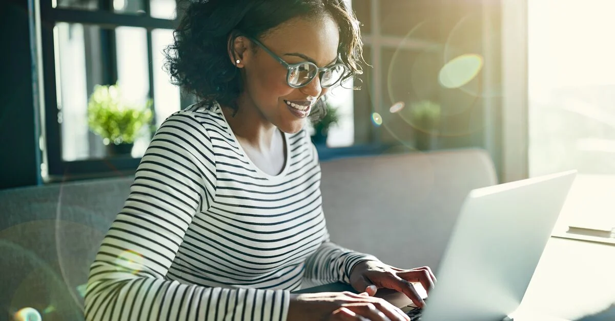 Young woman smiling working on laptop