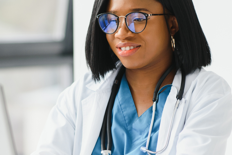 female healthcare worker with glasses sitting at computer