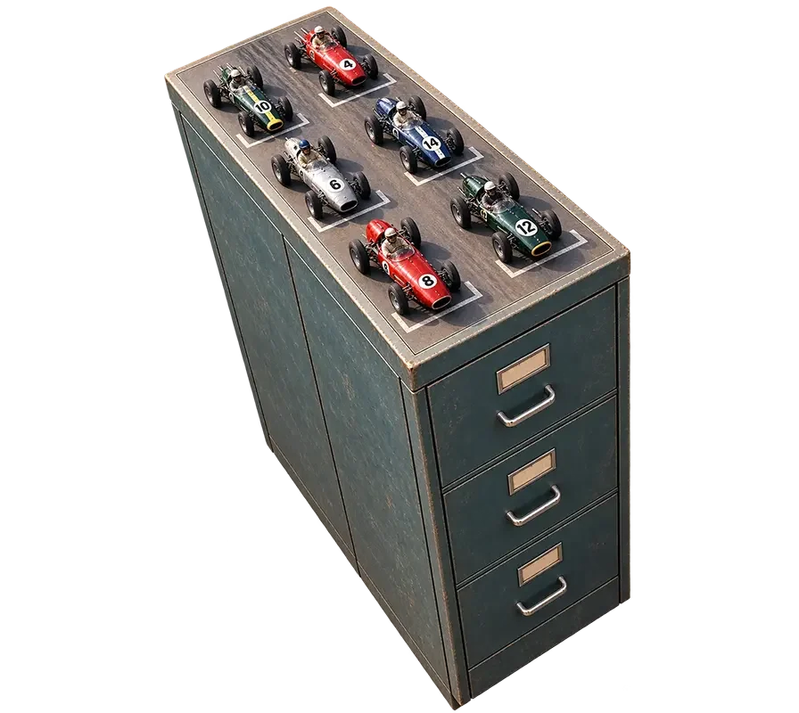 Six vintage toy race cars in red, silver, blue, and green displayed on top of a dark green metal filing cabinet.