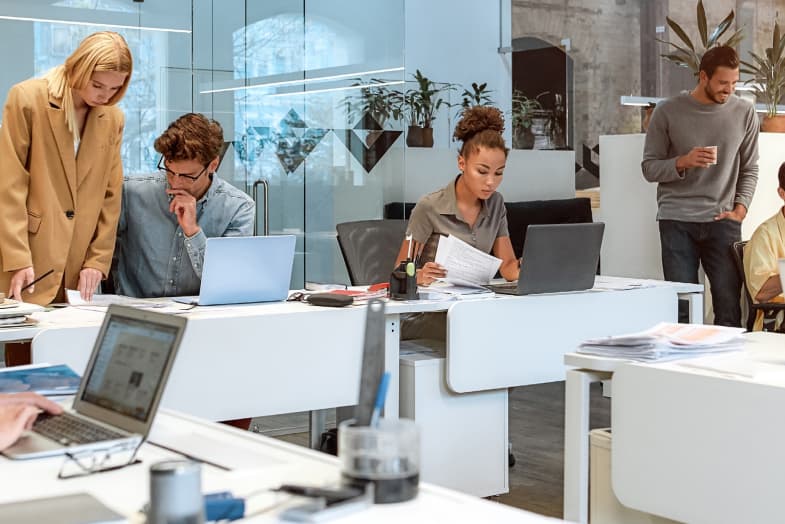 young, casual open office with coworkers sitting at desks working and collaborating