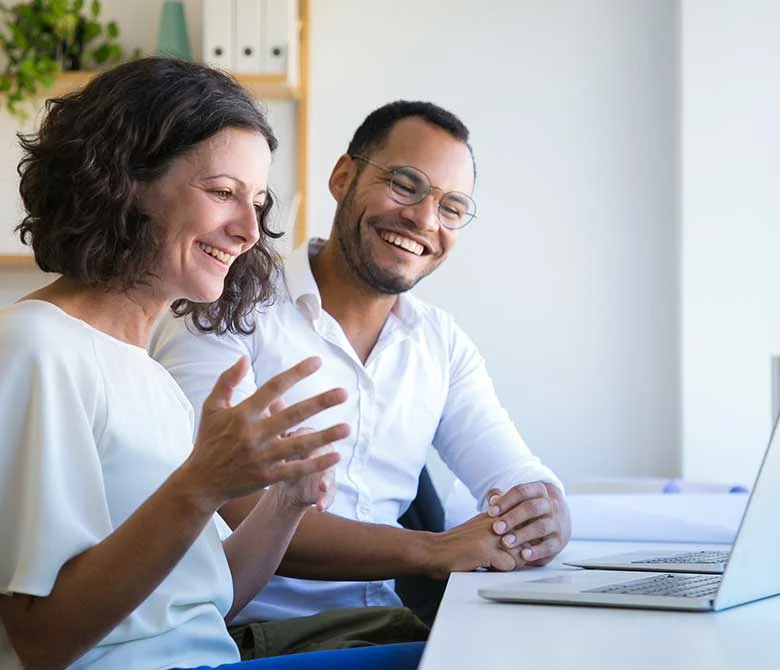 Female and Male colleague sitting at laptop on a virtual meeting.