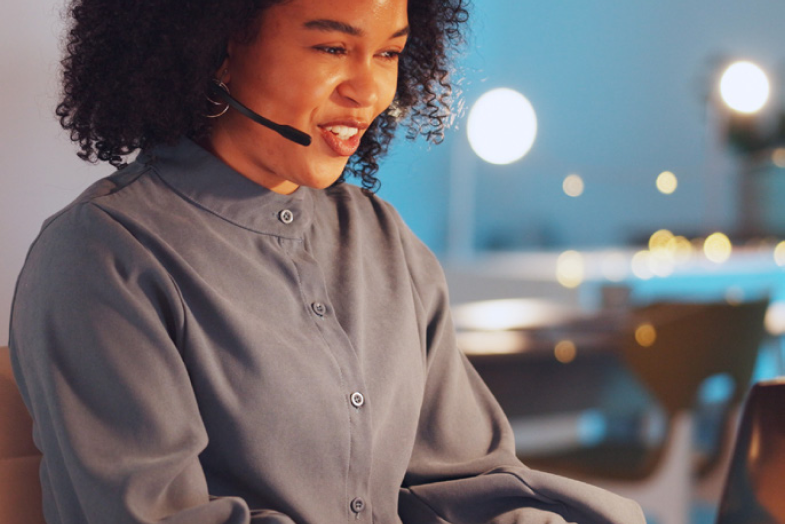 woman wearing headset talking on computer