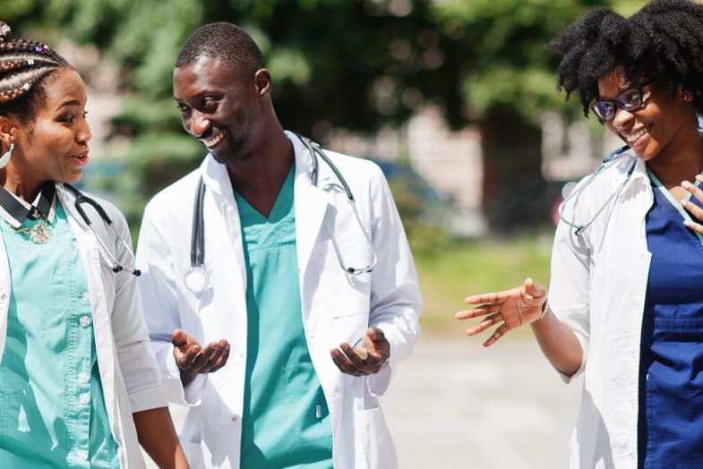 young medical professionals walking outside smiling and chatting