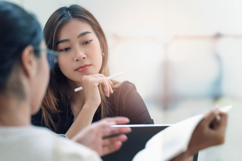 Two young women working on report together