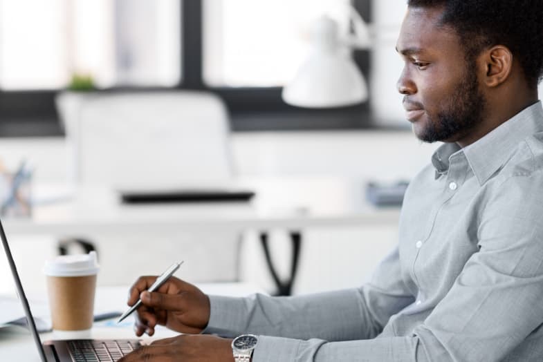 man in office wear sitting at desktop computer