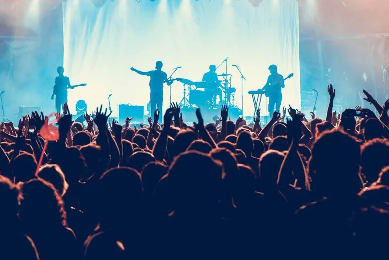 rockband on stage with large concert crowd
