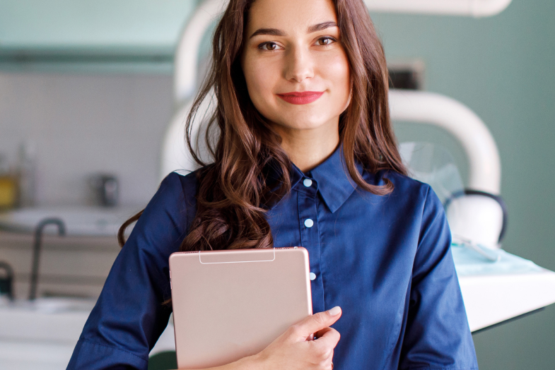 young female professional carrying tablet in dental office