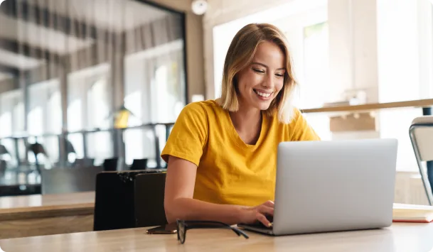 Phenom Free Tools - woman working in office smiling at her laptop