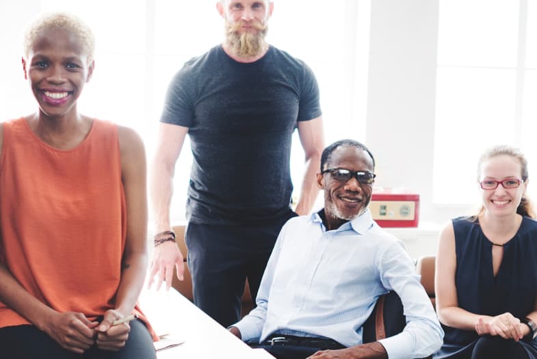 group of colleagues sitting and smiling at camera