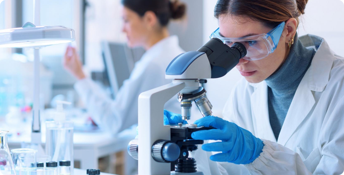 Medical Researcher in lab looking into microscope