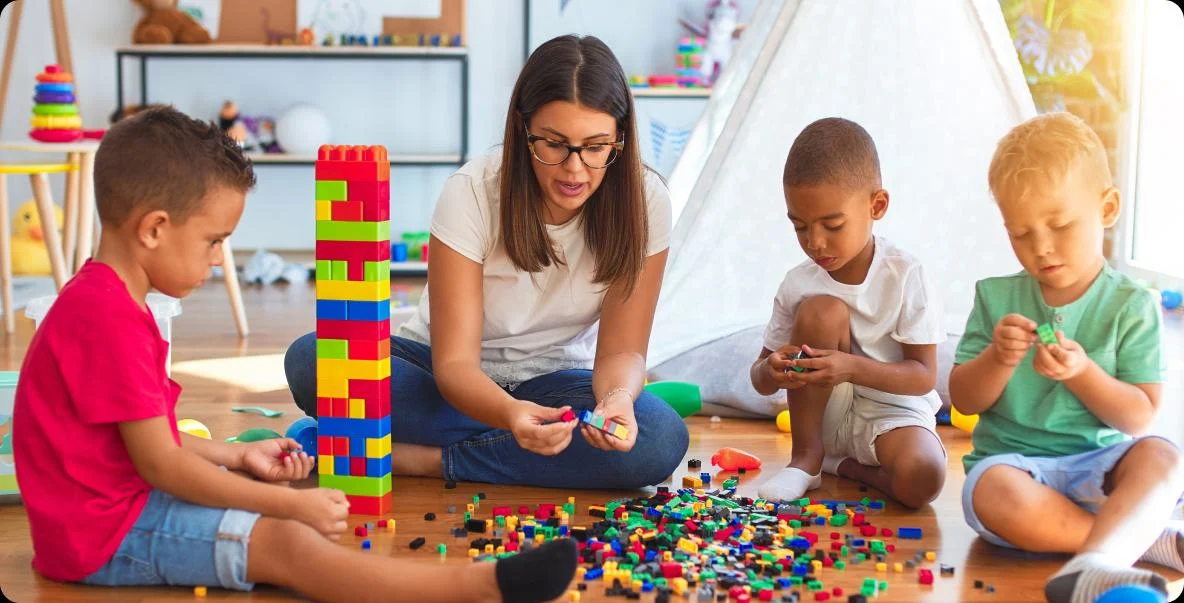 early education teacher with students building legos