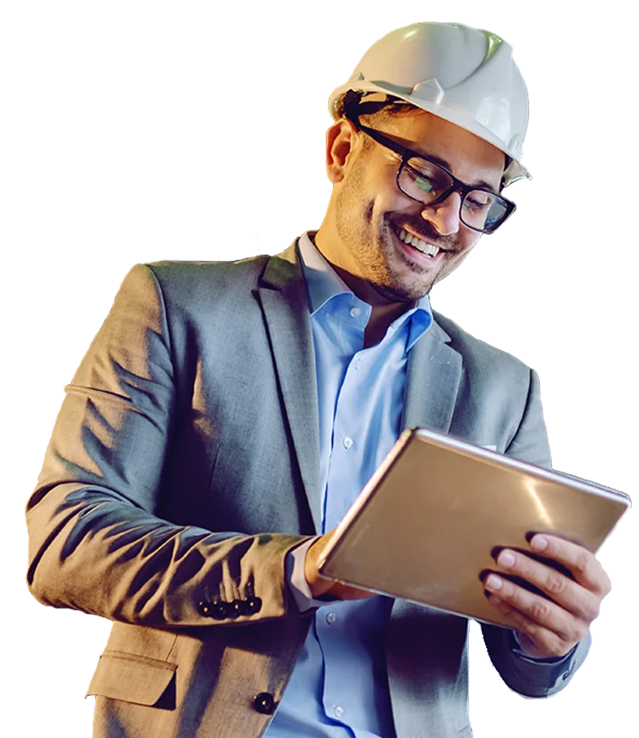 Young white male power plant manager in gray suit with helmet on head using tablet.