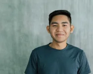 Man smiling at camera with grey background