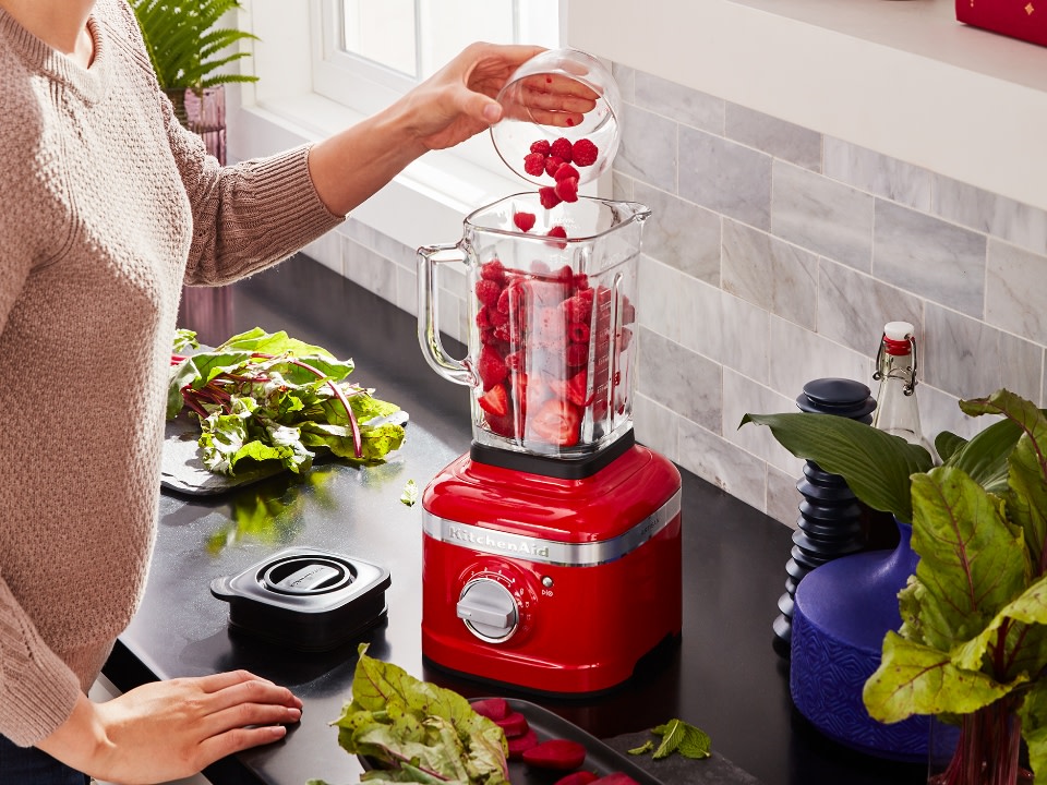 Blender-accessories-glass-jar-1.4L-empire-red-blender-woman-putting-ingredients-in-jar
