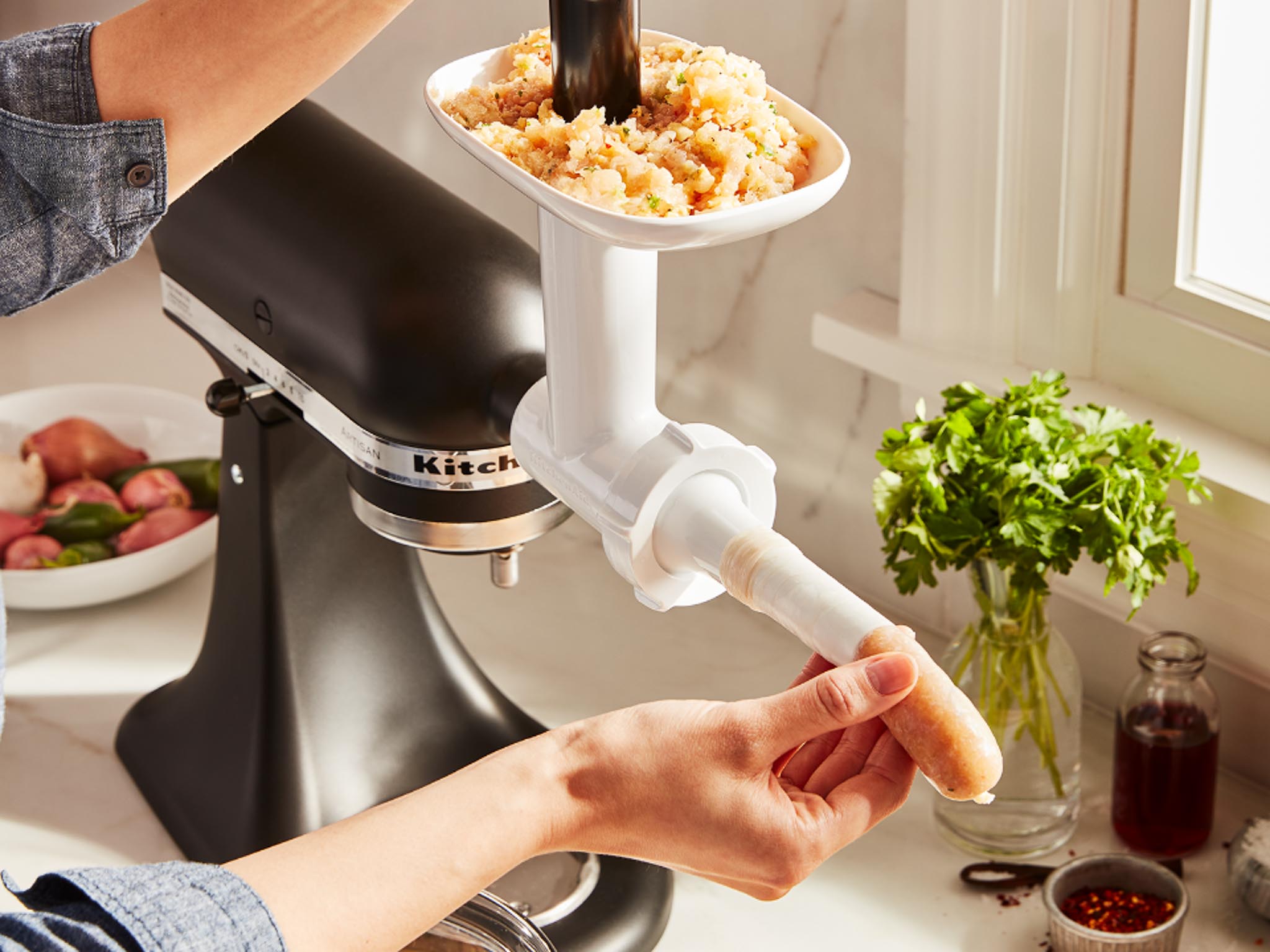 Mixer-attachments-sausage-stuffer-extension-pack-person-making-sausage-with-stuffer-tube-by-pushing-meat-through-the-meat-grinder-attachment