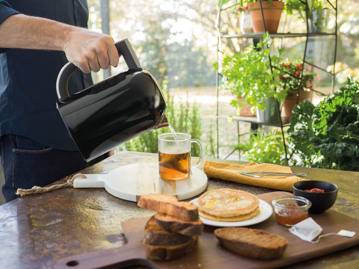 Pouring-water-to-tea-with-black-electric-kettle