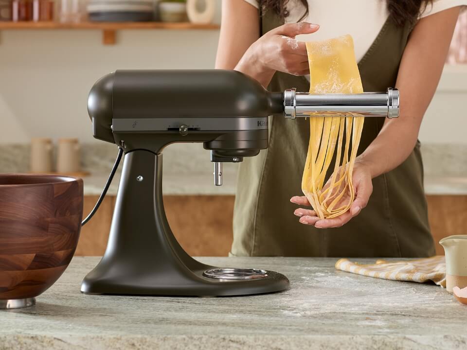 Evergreen-stand-mixer-person-pressing-pasta-using-pasta-press-attachnment