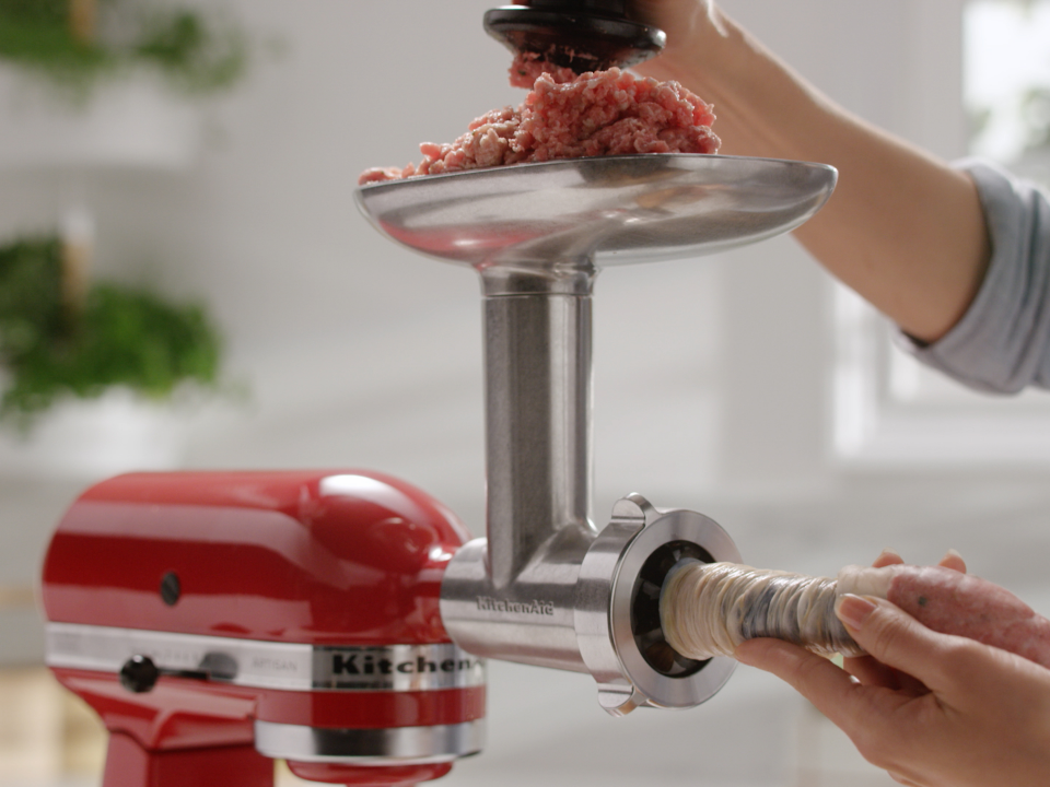 Mince-being-pushed-through-grinder-attachment-and out-the sausage