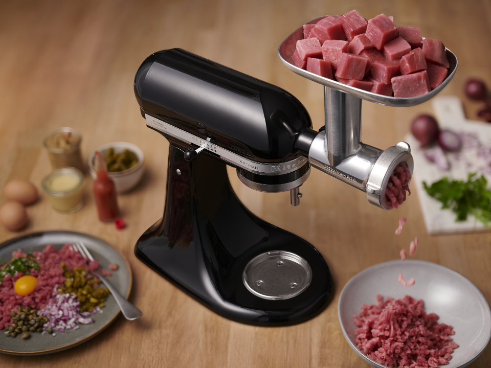 Stand-mixer-and-meat-grinder-and-sausage-stuffer-attachment-on-table-grinding-raw-meat