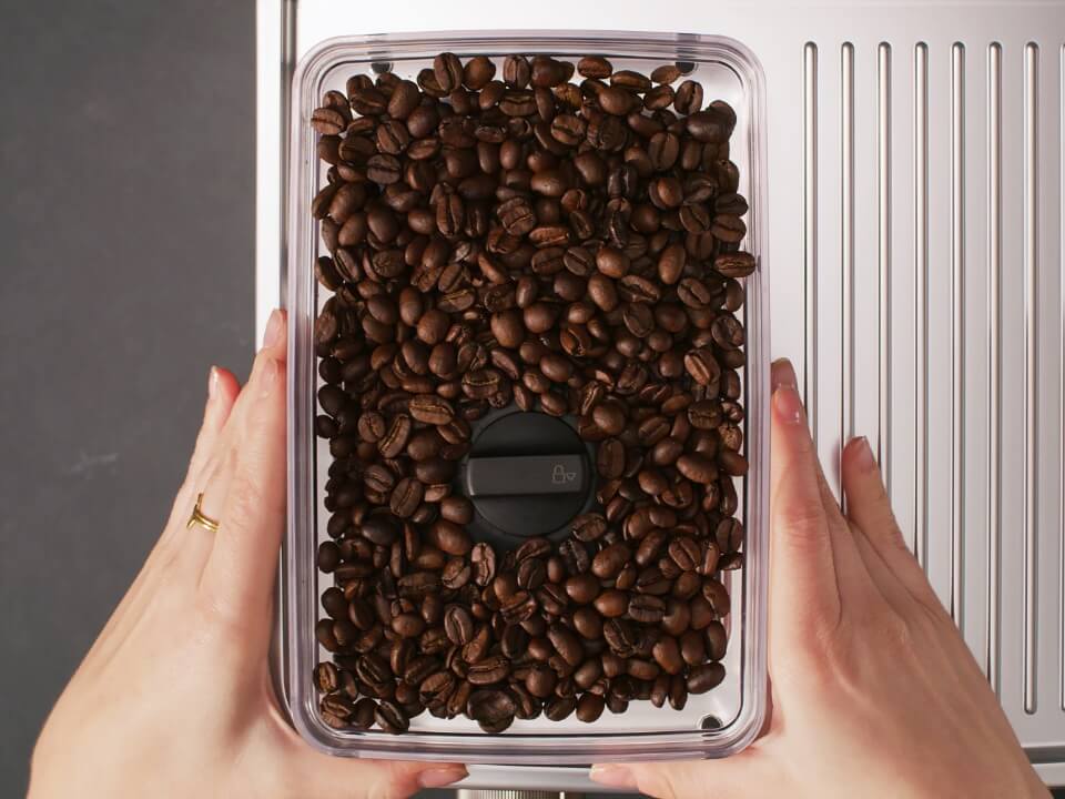 Removable-bean-hopper-with-lid-semi-automatic-KESRBHS-top-view-of-a-person-easily-replacing-the-bean-hopper-with-different-type-of-coffee-bean