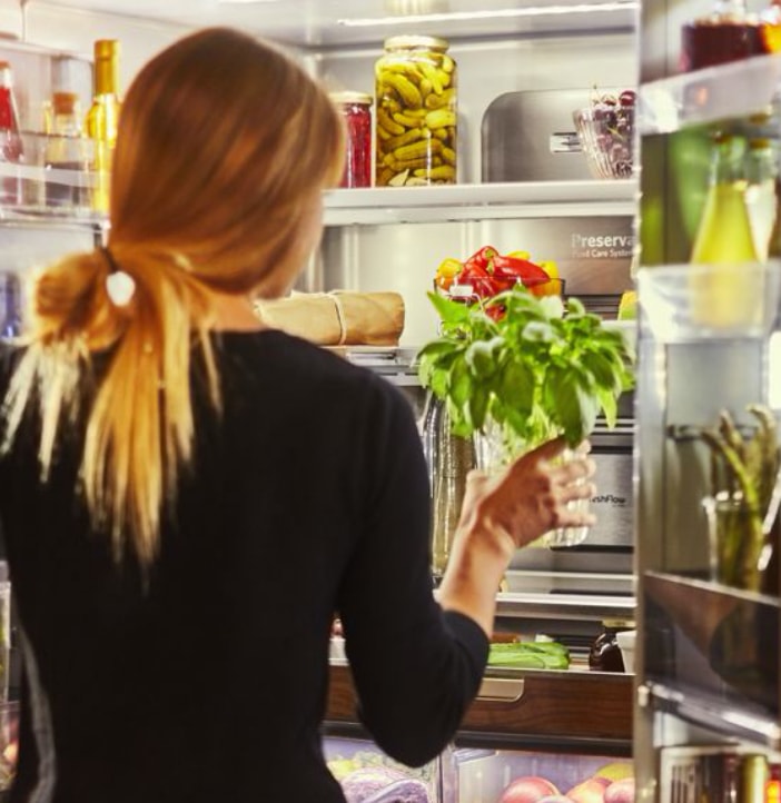 Woman-putting-food-away-to-the-fridge