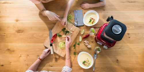 family-cutting-vegetables-for-soup-and-red-blender