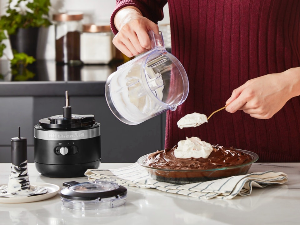 Food-chopper-cordless-in-black-cast-iron-used-for-whisked-cream-over-chocolate-cake