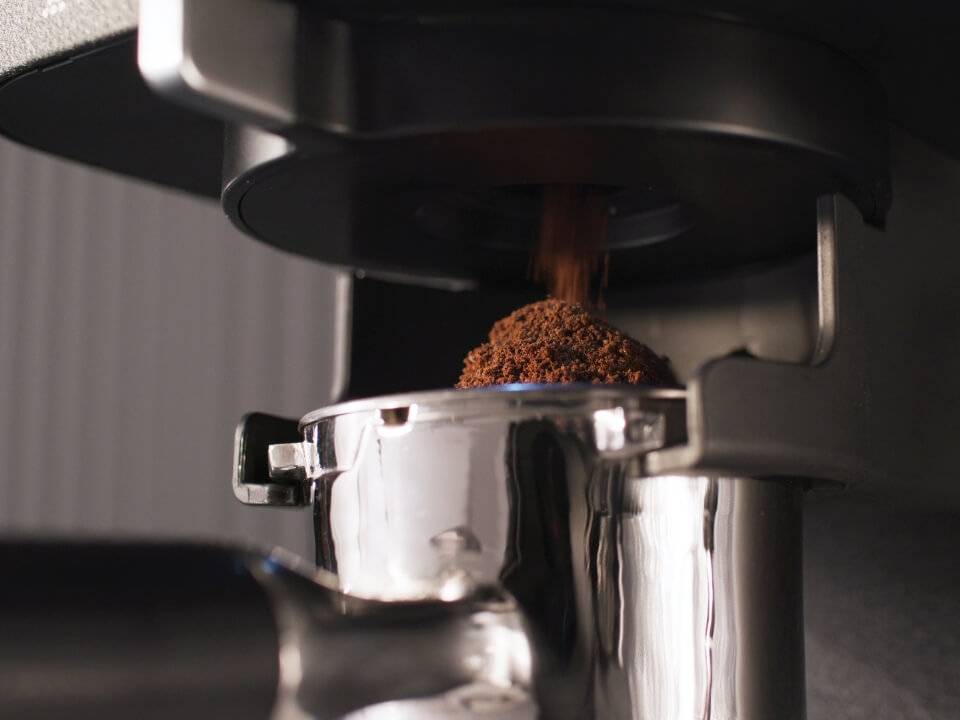 Semi-automatic-espresso-machine-with-burr-grinder-5KES6551-close-up-of-ground-coffee-falling-into-portafilter