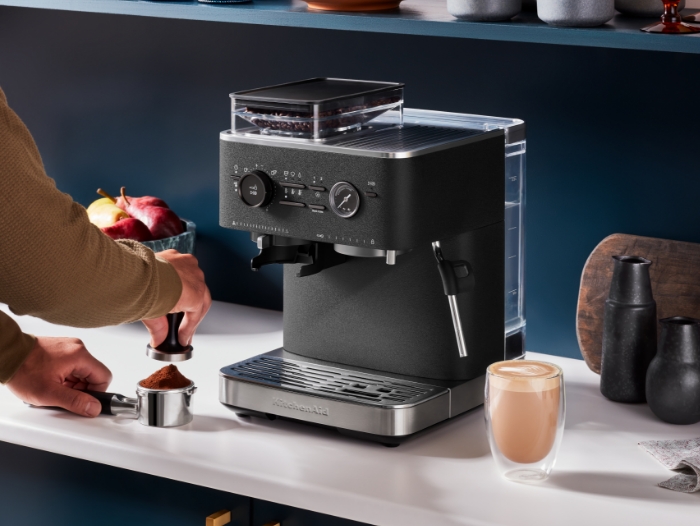 column-content-wrapper-person-tamping-coffee-next-to-semi-automatic-espresso-machine-with-burr-grinder