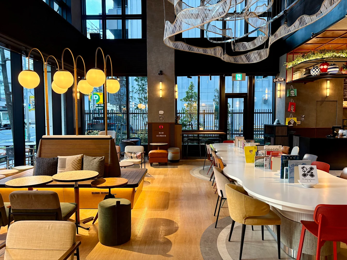 Lobby với dãy đèn tròn và cửa kính lớn nhìn ra phố