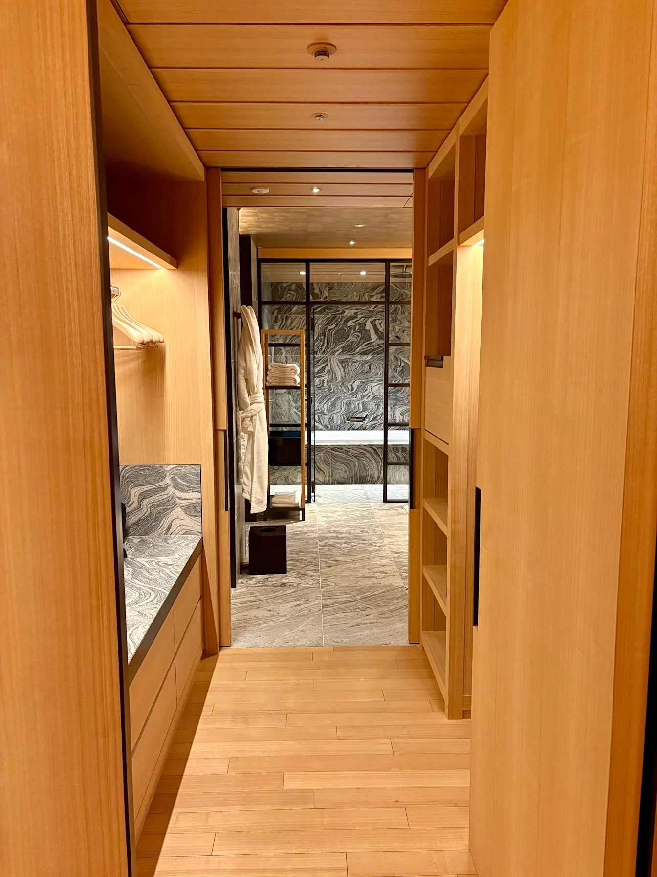 Khu tủ quần áo bằng gỗ dẫn vào phòng tắm của Park Suite Garden View