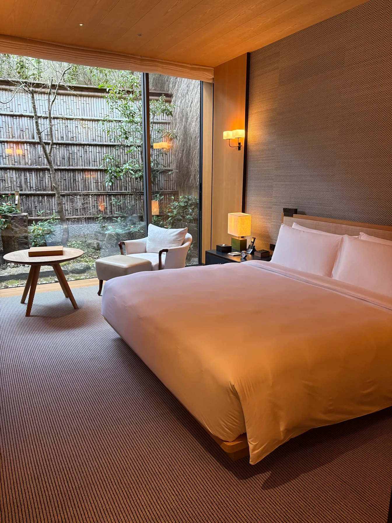 Phòng ngủ Park Suite Garden View với cửa kính lớn nhìn ra vườn