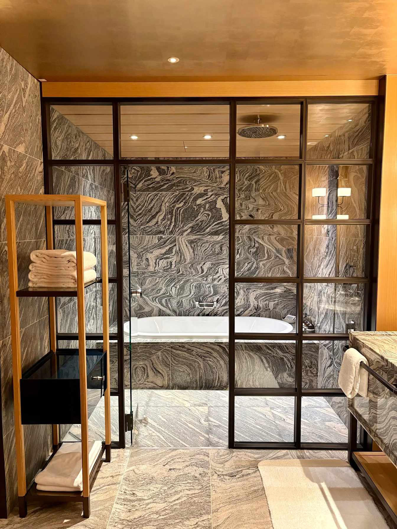 Phòng tắm đá marble với bồn tắm và vòi sen trong Park Suite Garden View