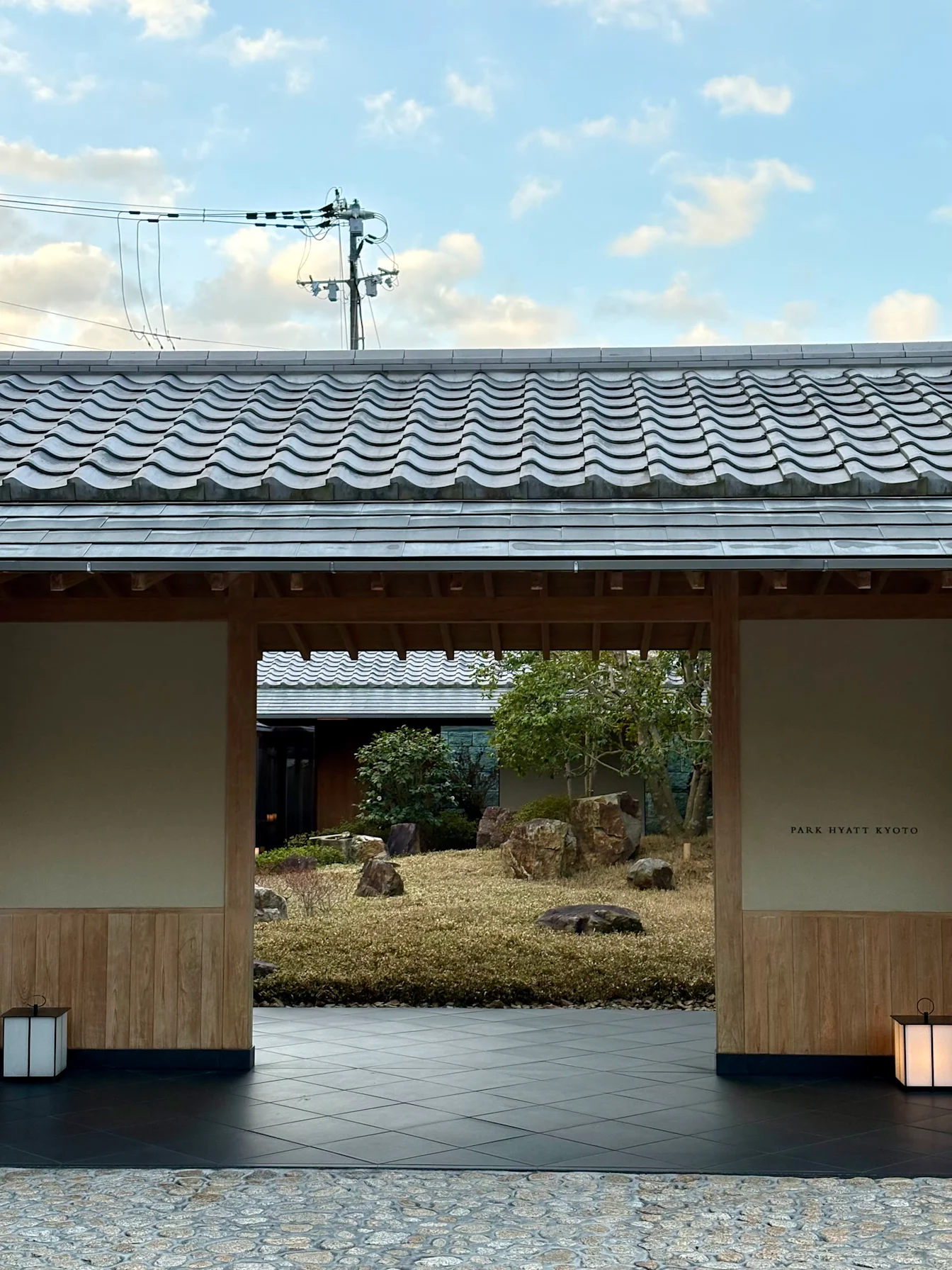 Cổng gỗ mái ngói nhìn vào khu vườn đá của Park Hyatt Kyoto