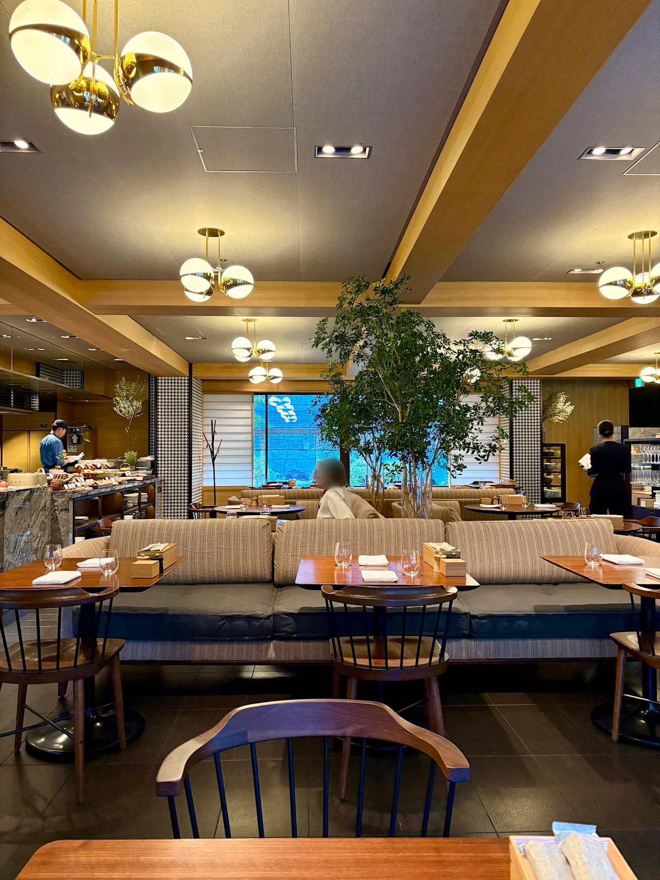 Không gian Kyoto Bistro với ghế sofa và cây xanh giữa phòng