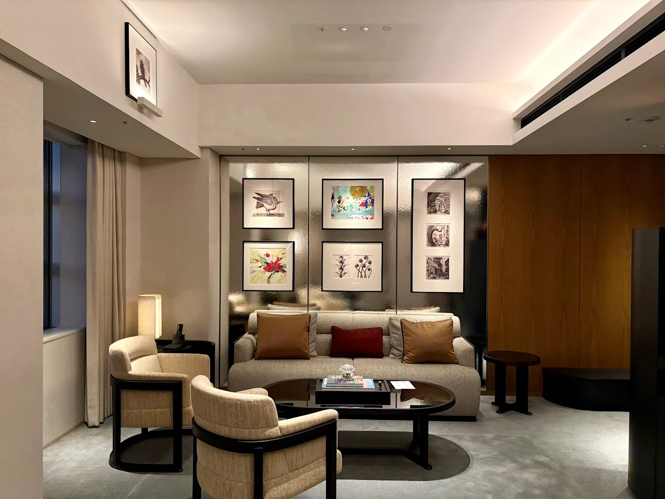 Khu phòng khách với sofa và tranh treo tường trong King Suite Deluxe