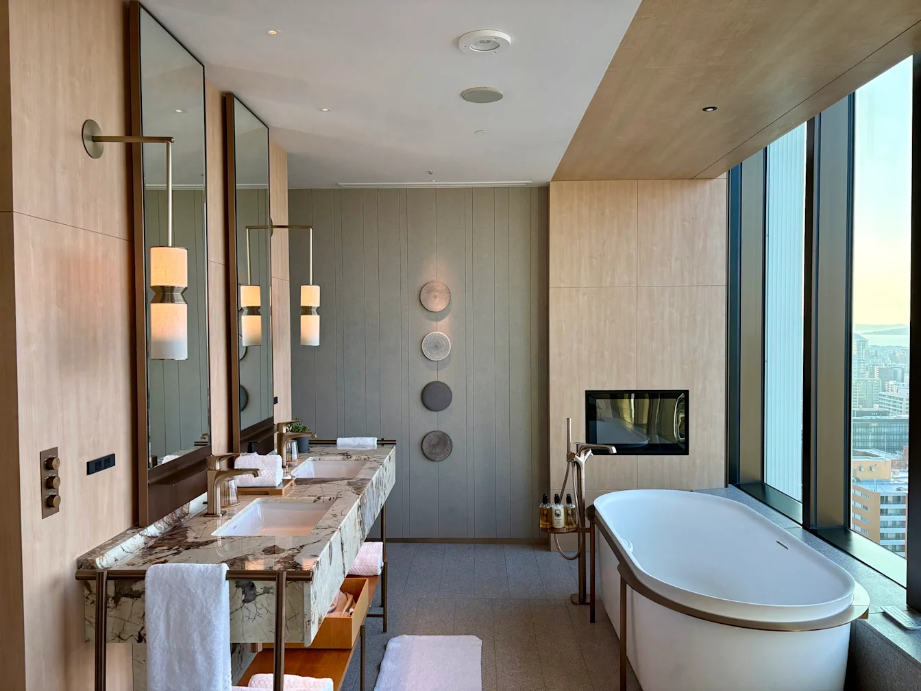Phòng tắm mở với double vanity và bồn tắm cạnh cửa kính