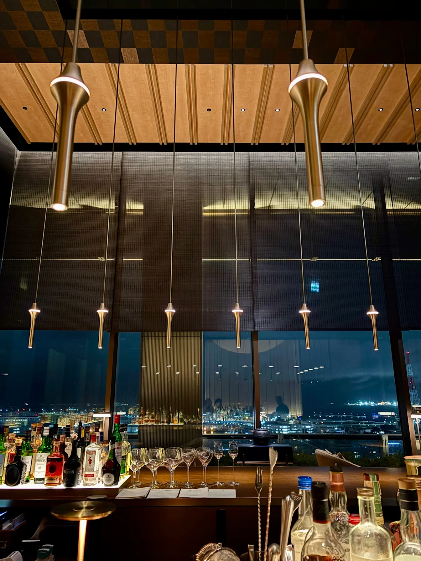 Quầy bar với đèn thả và view thành phố về đêm