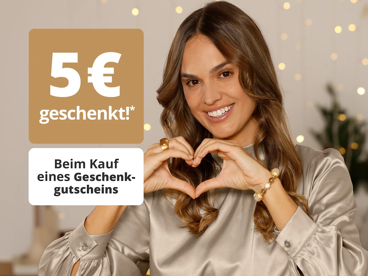 Frau in beigem Satin-Oberteil formt mit den Händen ein Herz. Links steht „5 € geschenkt! Beim Kauf eines Geschenkgutscheins“. Frau in beigem Satin-Oberteil formt mit den Händen ein Herz. Links steht „5 € geschenkt! Beim Kauf eines Geschenkgutscheins“.