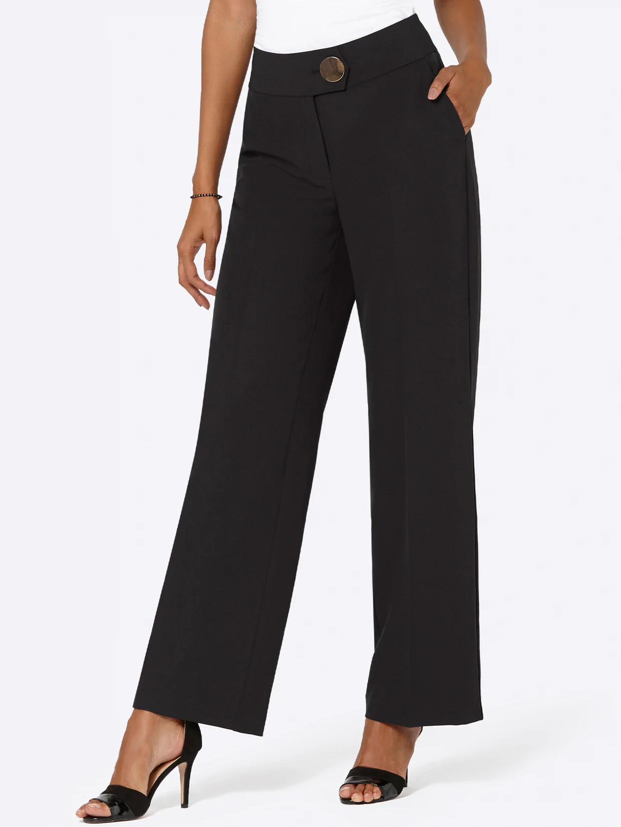 Schwarze, weit geschnittene Damenhose mit hohem Bund, dekorativer Knopfleiste und Taschen, kombiniert mit schwarzen High-Heels. Schwarze, weit geschnittene Damenhose mit hohem Bund, dekorativer Knopfleiste und Taschen, kombiniert mit schwarzen High-Heels.