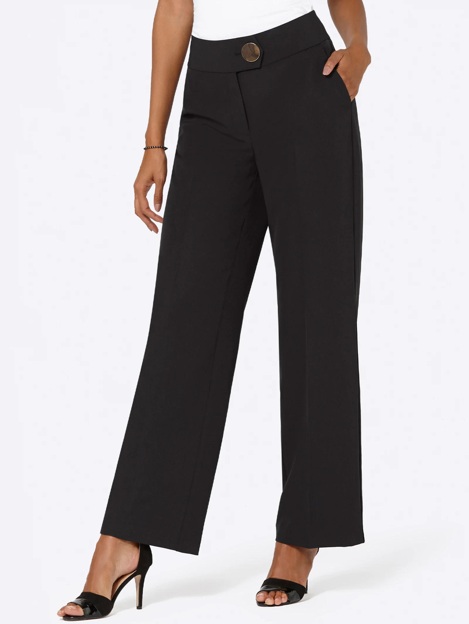 Schwarze, weit geschnittene Damenhose mit hohem Bund, dekorativer Knopfleiste und Taschen, kombiniert mit schwarzen High-Heels. Schwarze, weit geschnittene Damenhose mit hohem Bund, dekorativer Knopfleiste und Taschen, kombiniert mit schwarzen High-Heels.