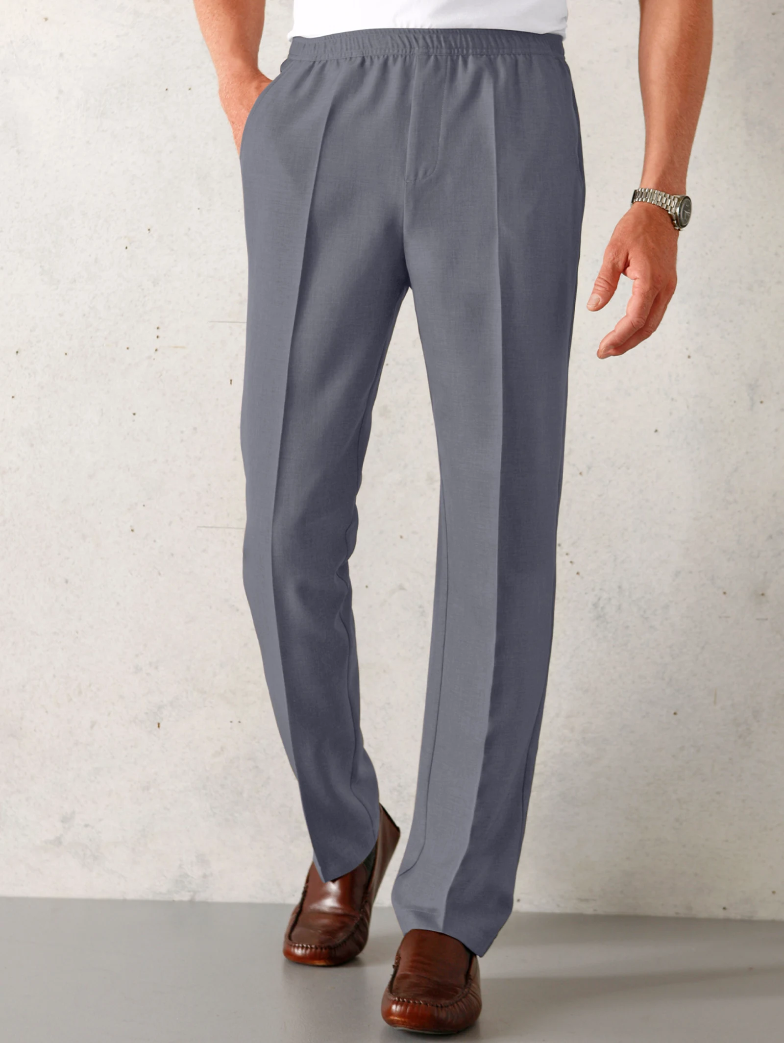 Graue Herrenhose mit elastischem Bund und Bügelfalte, kombiniert mit braunen Lederschuhen. Graue Herrenhose mit elastischem Bund und Bügelfalte, kombiniert mit braunen Lederschuhen.